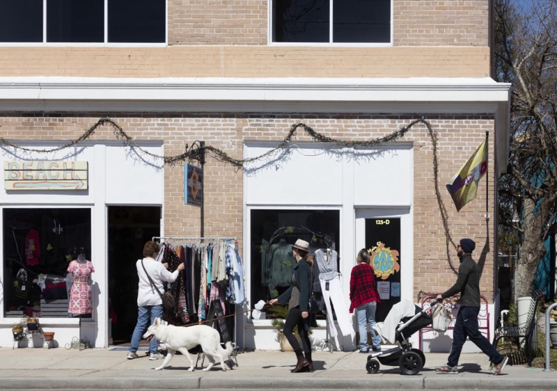People walking past brick storefronts in Bay St. Louis in 2016