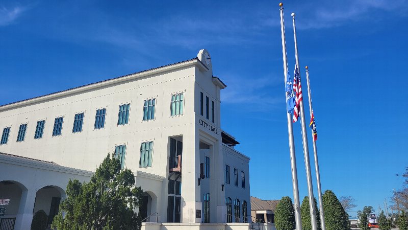 D’Iberville City Hall with flags and a blue sky.