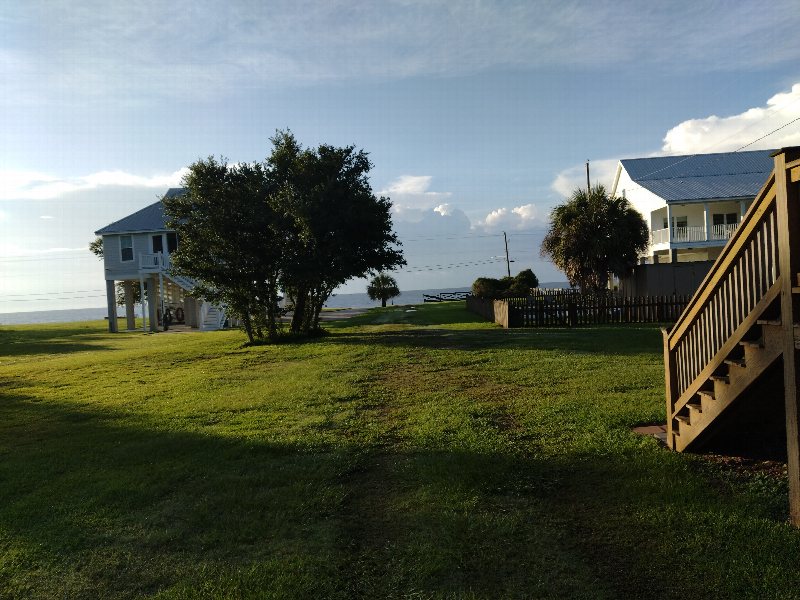 Raised coastal homes and lawns beside the shoreline in Waveland.