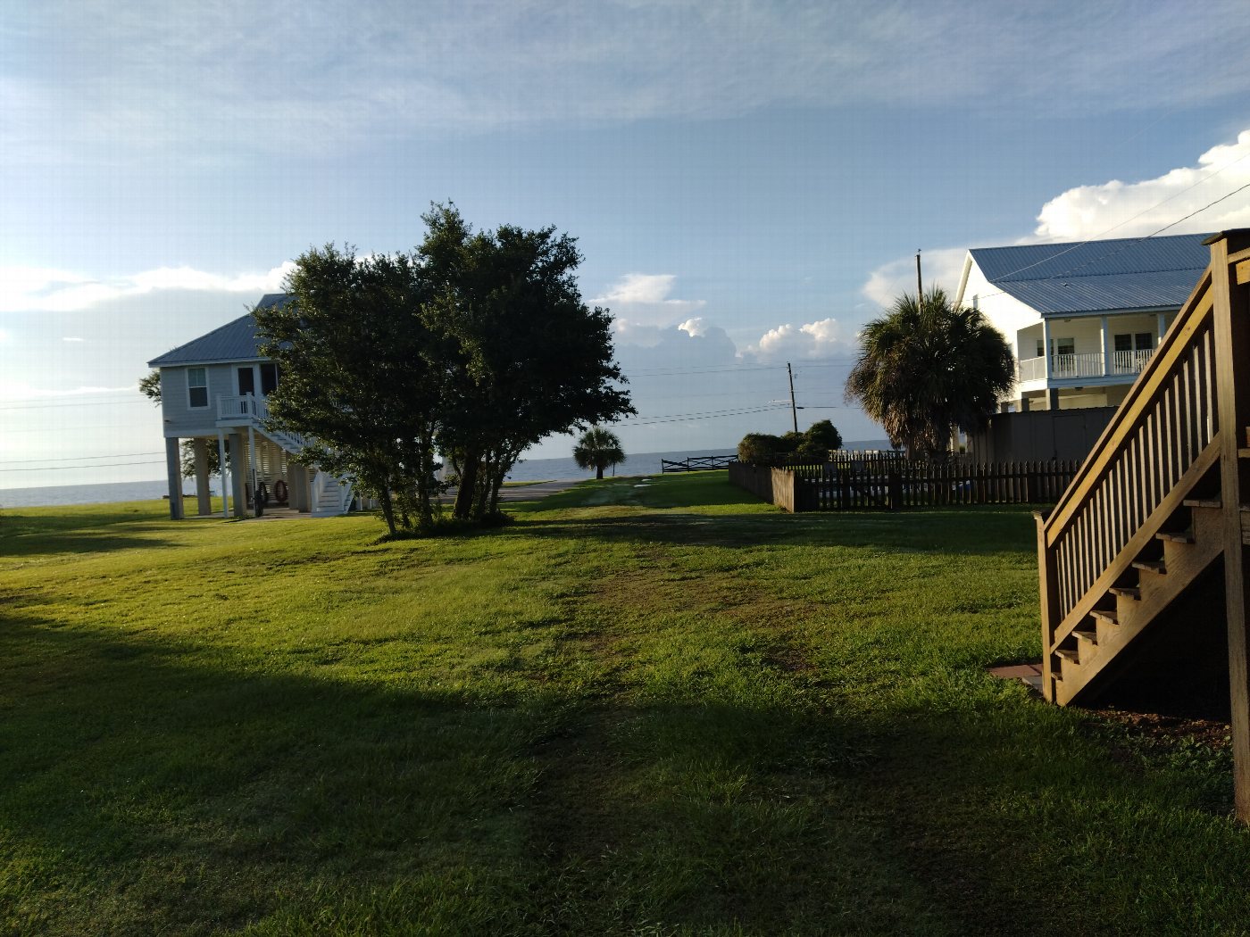 Raised coastal homes and lawns beside the shoreline in Waveland.